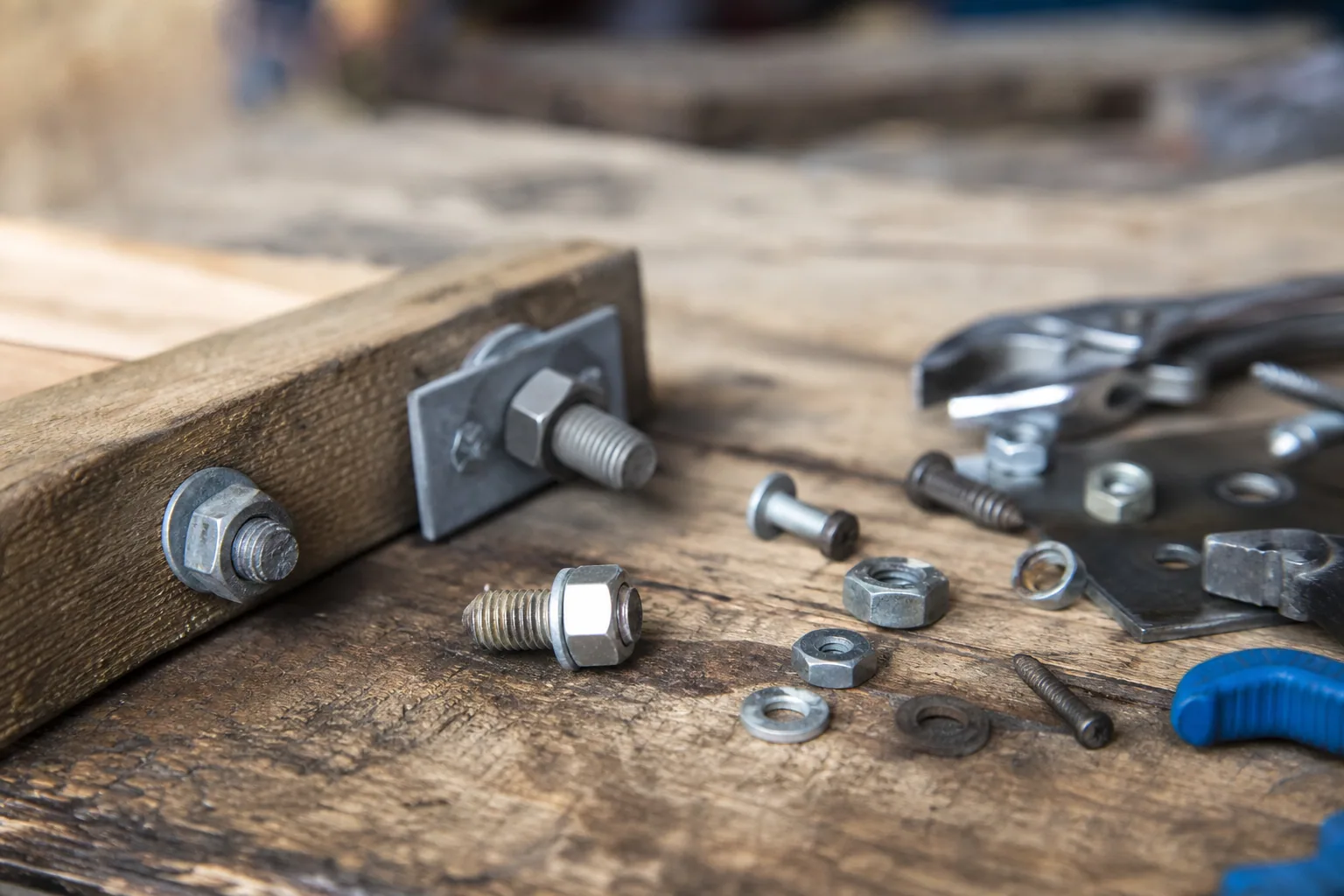 Gros plan sur une vis et un tournevis posés sur un établi en bois avec des outils de bricolage